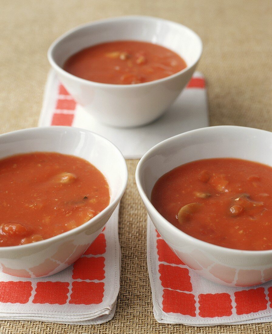 Tomato soup in three white bowls