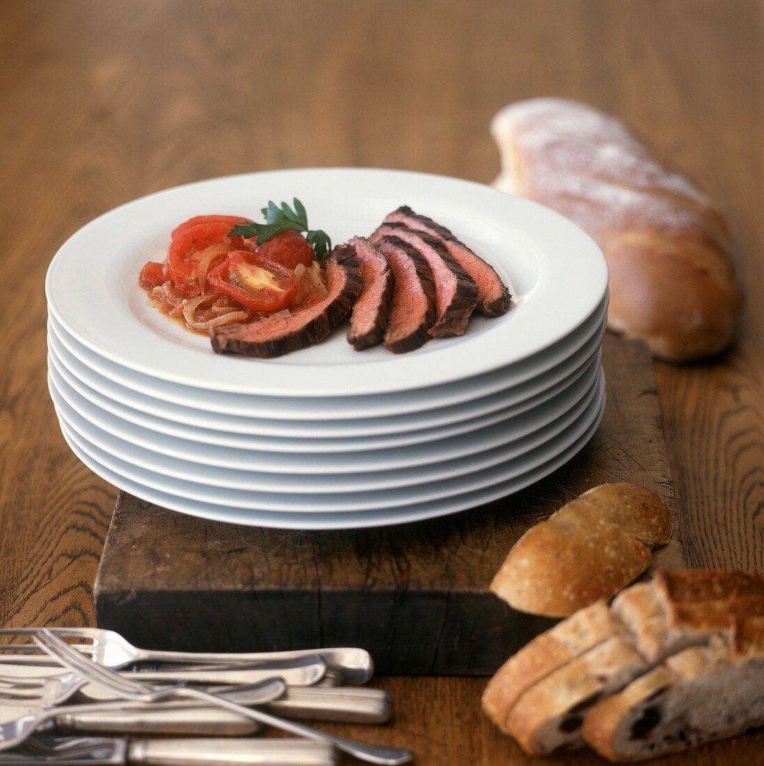 Beef steak with tomatoes and onions; olive bread