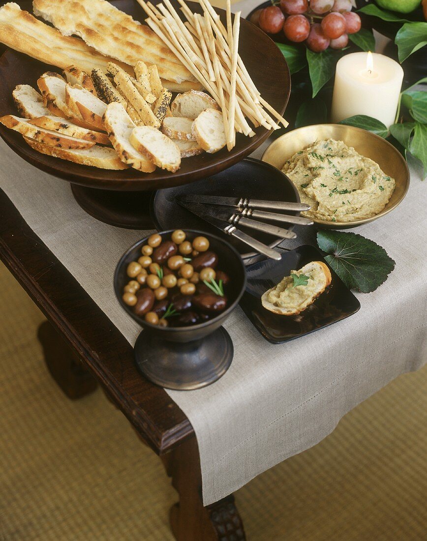 Buffet mit Oliven, Hummus und pikantem Gebäck