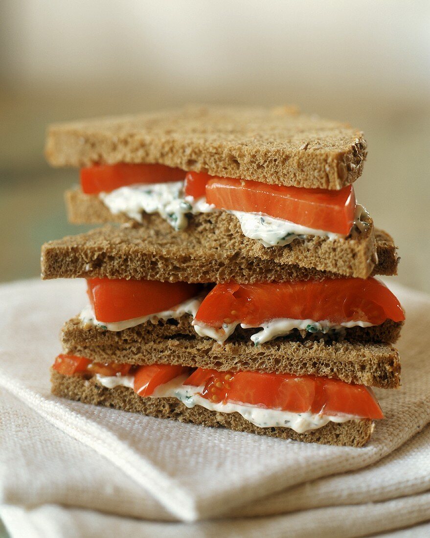 Triple Layer Sandwich with Herbed Cheese and Tomatoes on Whole Wheat Bread