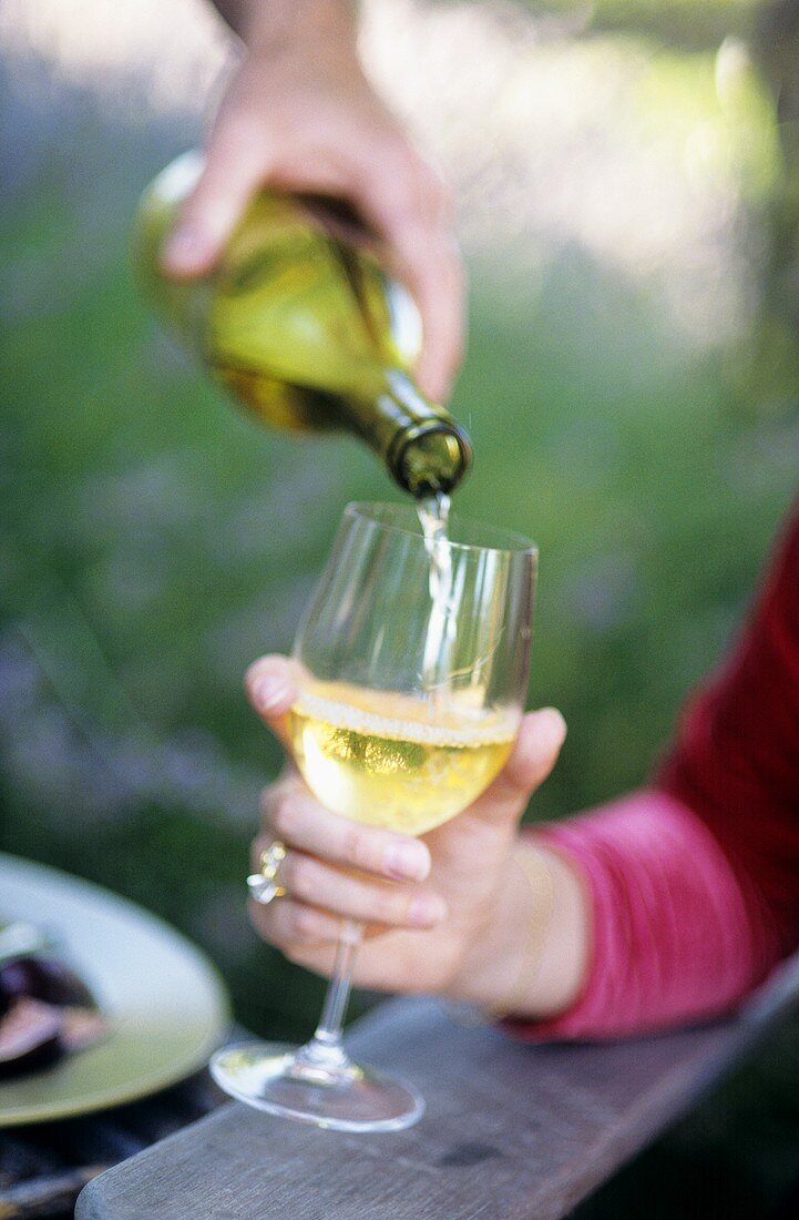 Pouring a Glass of White Wine Outdoors