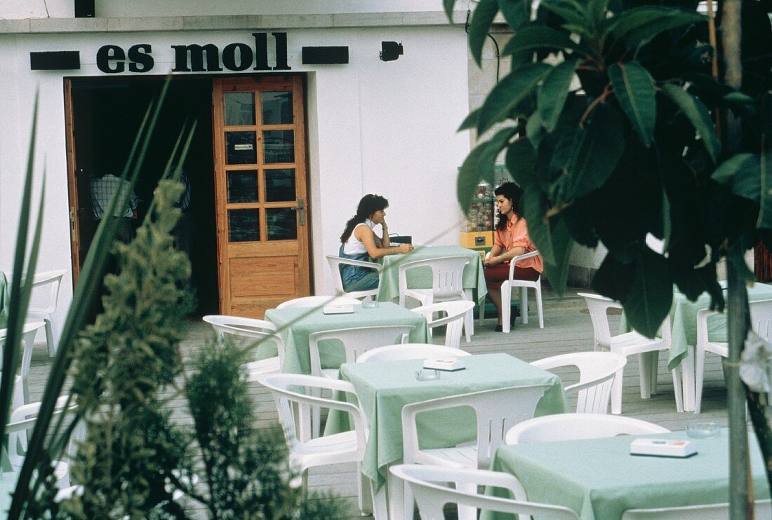 Zwei Frauen sitzen an einem Tisch in Café im Freien