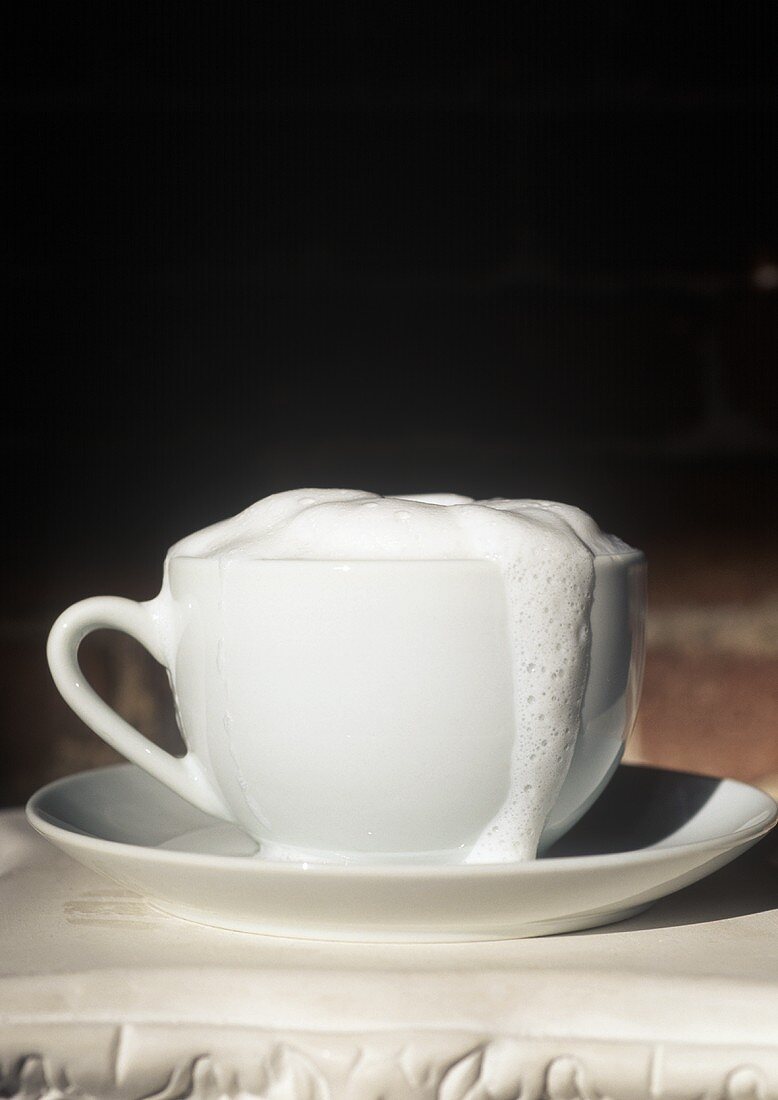 Tasse Cappuccino mit überschäumender Milch