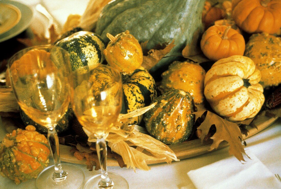 Verschiedene Kürbisse auf Platte als herbstliche Tischdeko