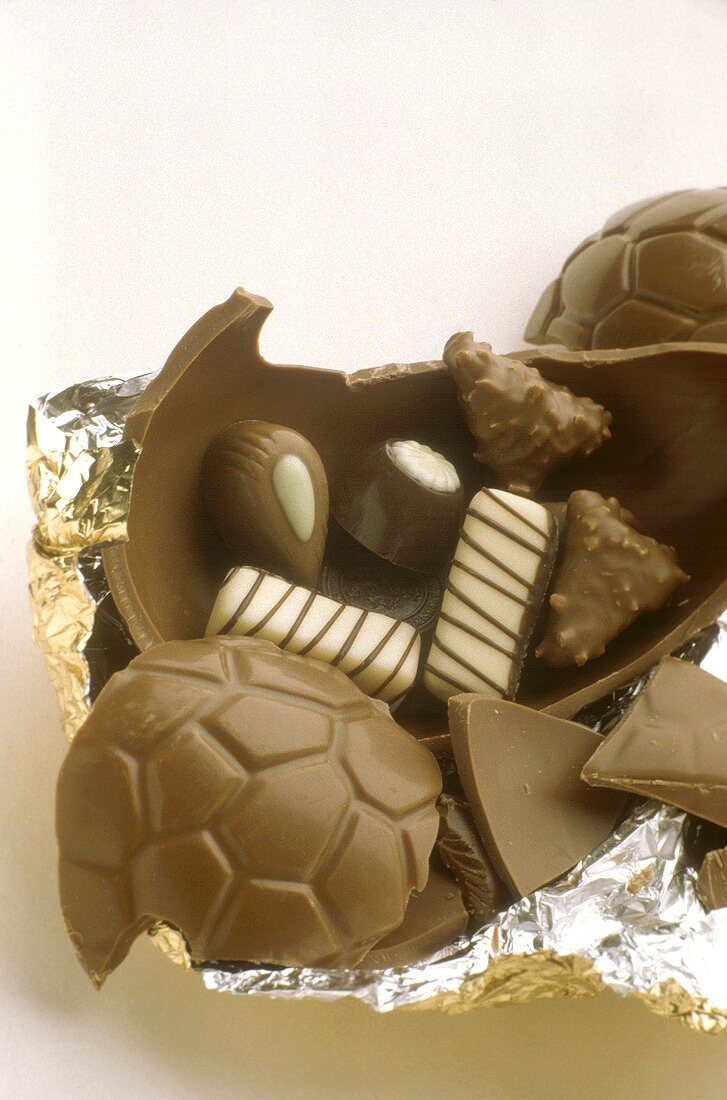 A Chocolate Easter Egg Cracked Open with Chocolate Candies