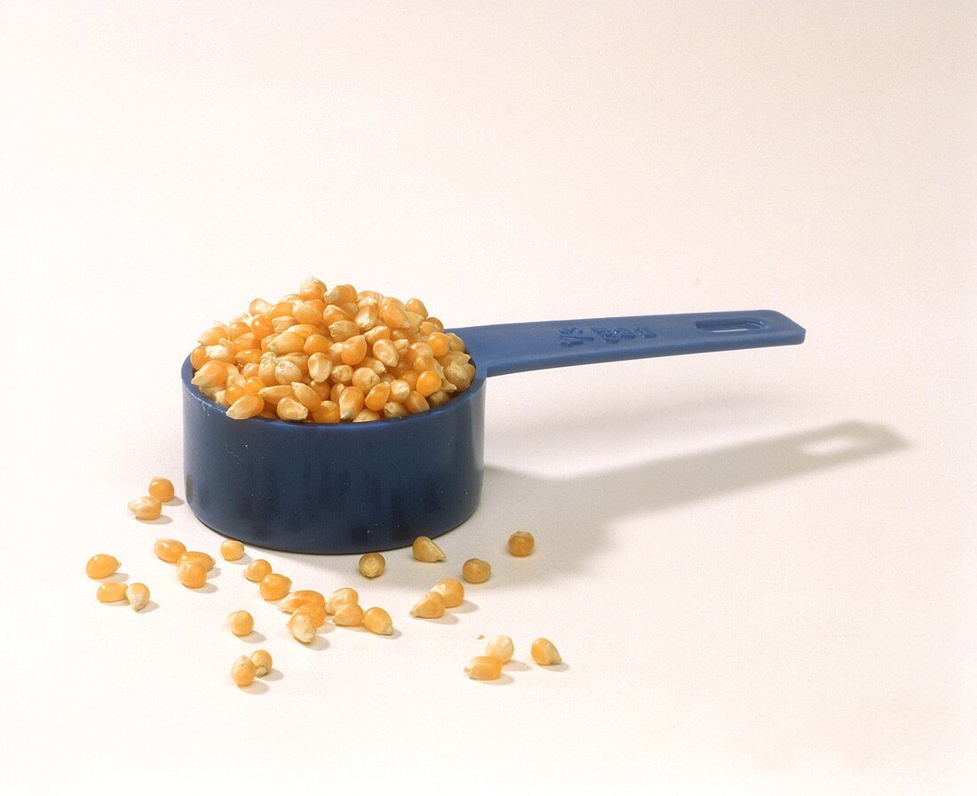 Maiskörner für Popcorn in einem blauen Messbecher
