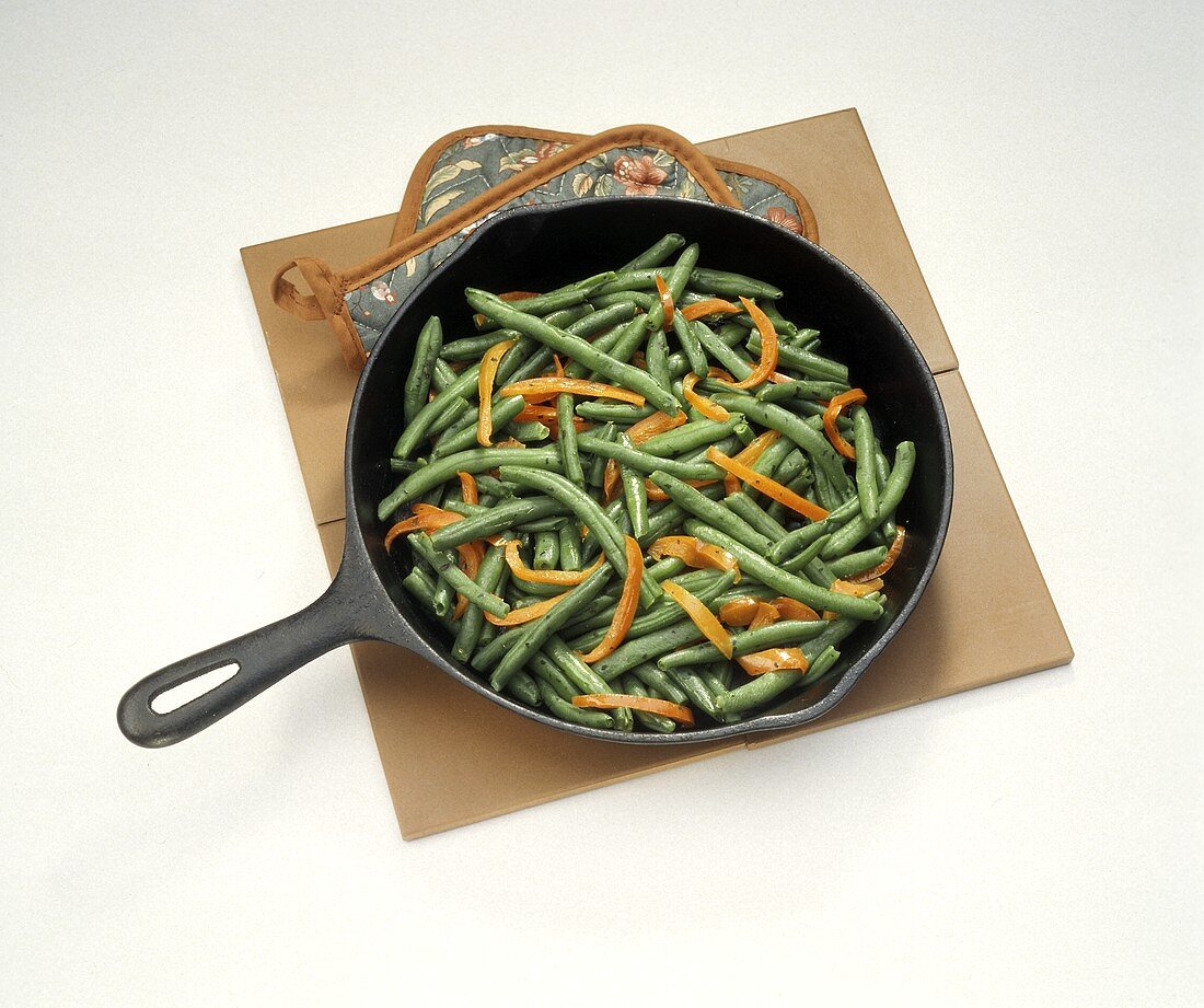 Sauteed Green Beans and Red Peppers in a Pan; Pot Holder