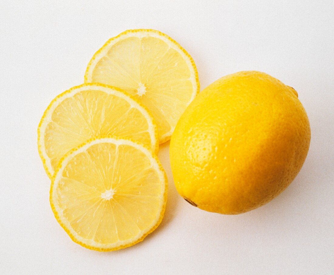 Eine Zitrone und drei Zitronenscheiben