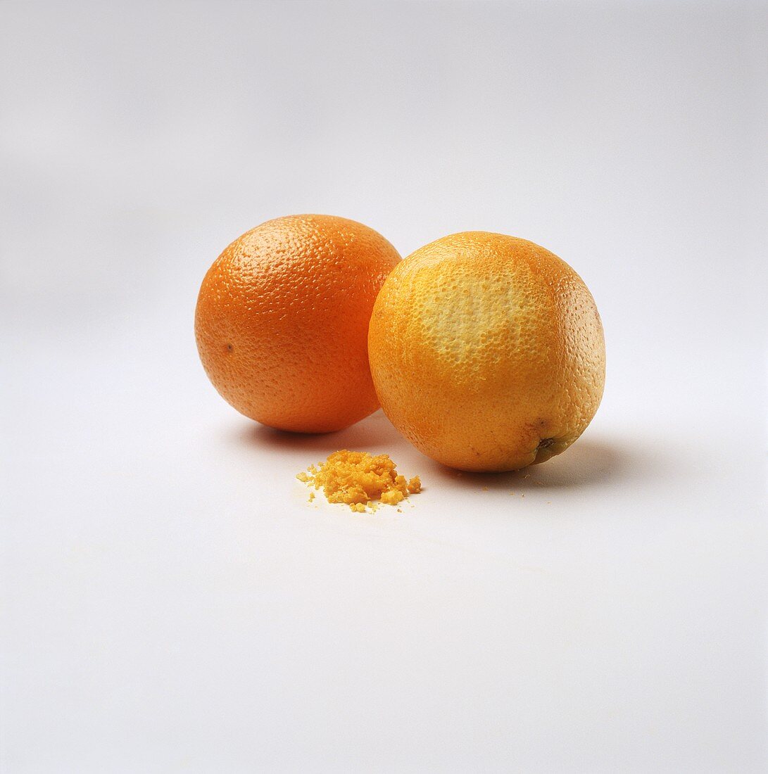 Zwei Orangen, eine mit abgeriebener Schale