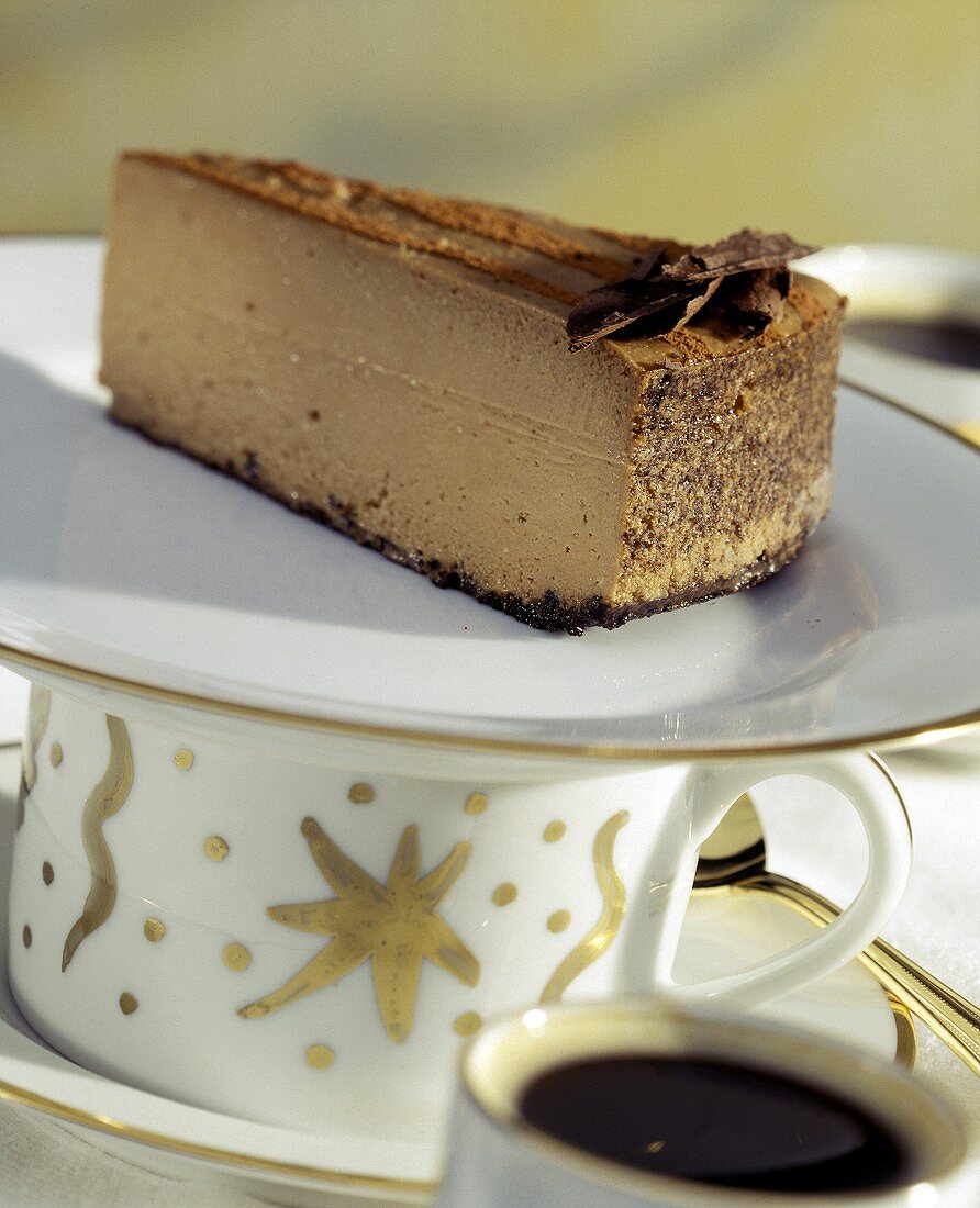 Ein Stück Schokoladen-Käse-Kuchen auf Teller über einer Tasse