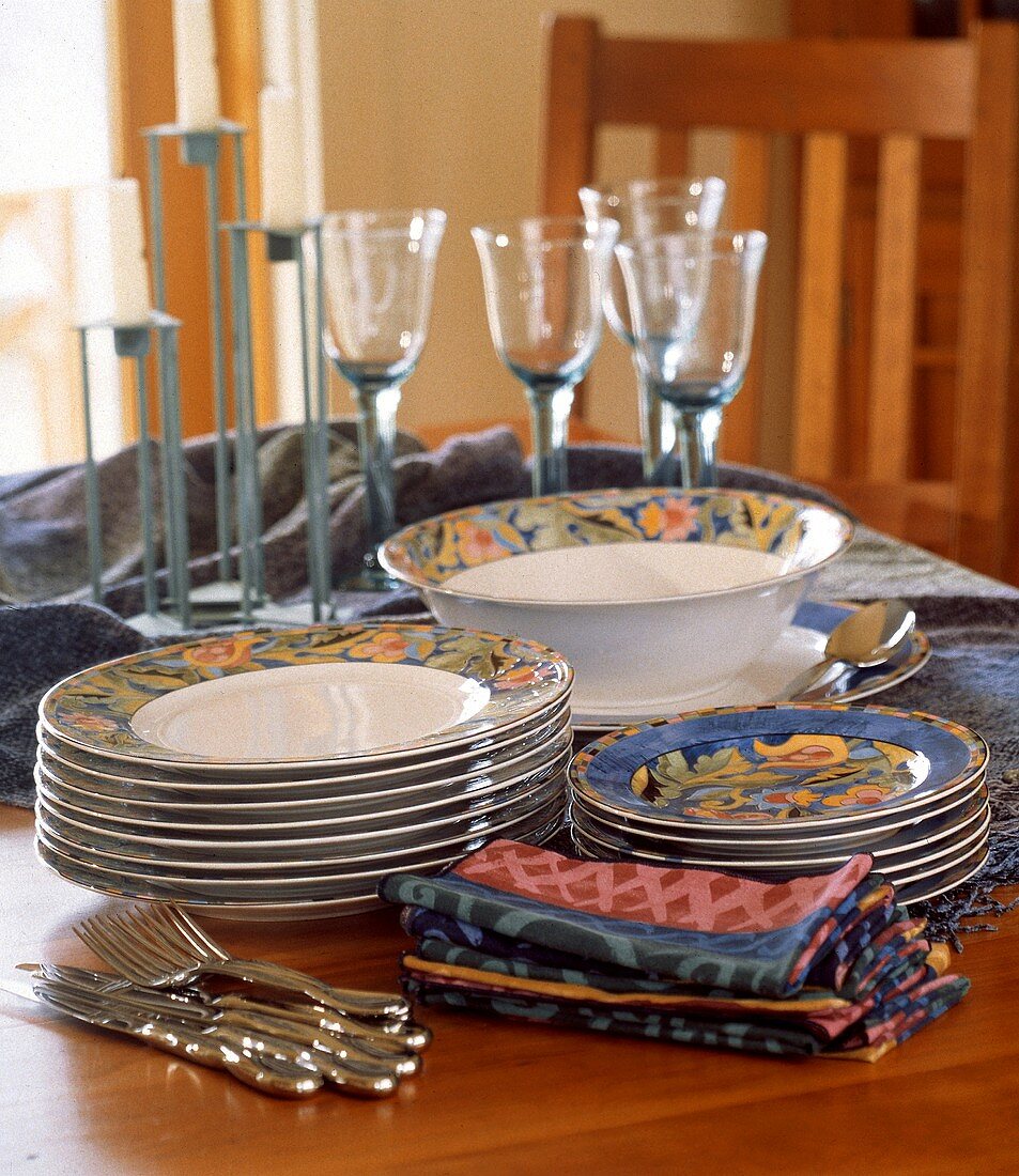 Stcked Plates Cloth napkins Silverware and Wine Glasses