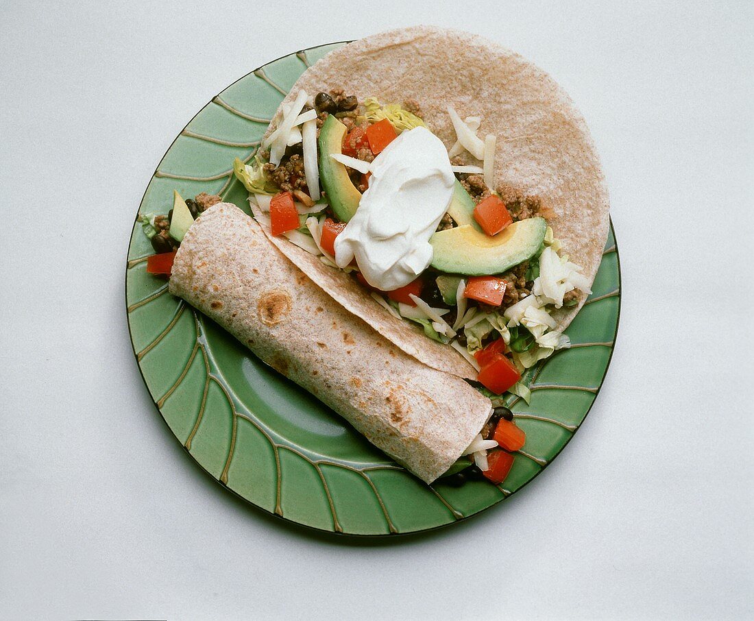 Zwei Burritos mit Gemüse-Hackfleischfüllung auf Teller