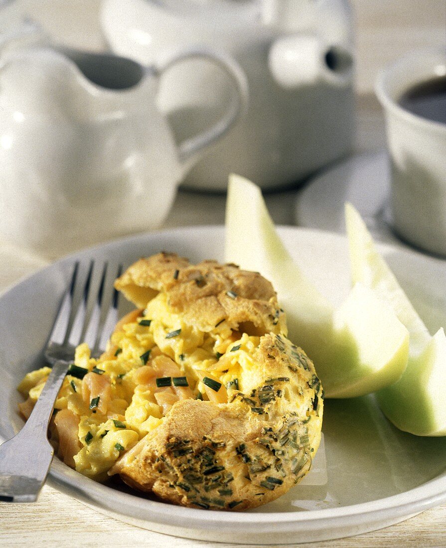A Popover Filled with Scrambled Eggs and Chives; Melon Slices