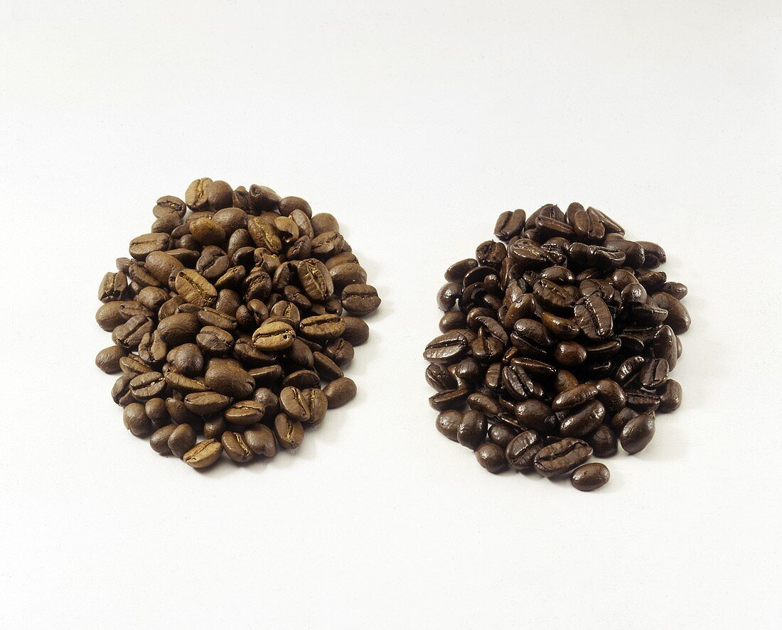 Zwei Häufchen Kaffeebohnen (stark geröstet und Mokkabohnen)