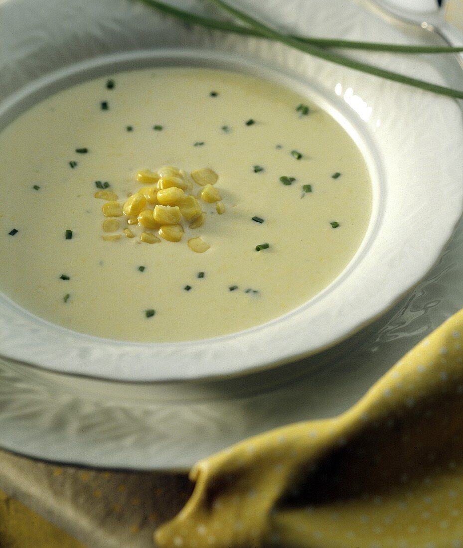 Maissuppe mit Schnittlauchröllchen auf weißem Teller