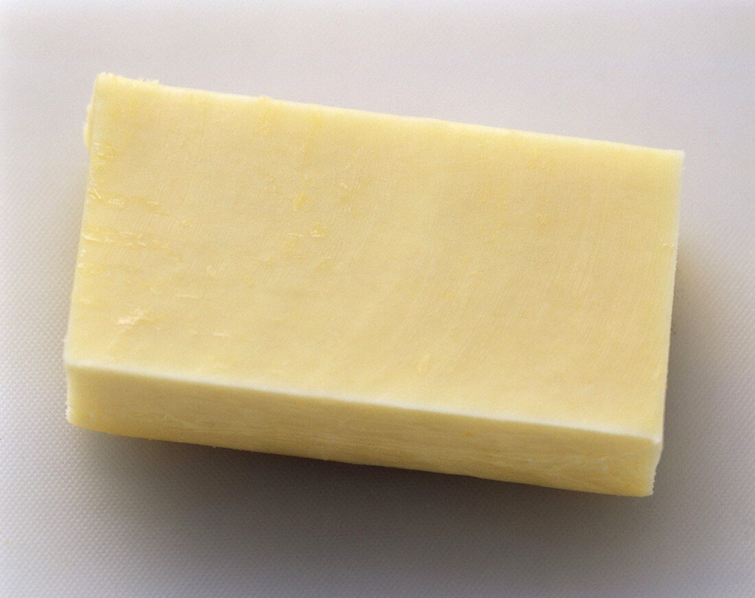 Ein Stück Monterey Jack Käse auf weißem Untergrund