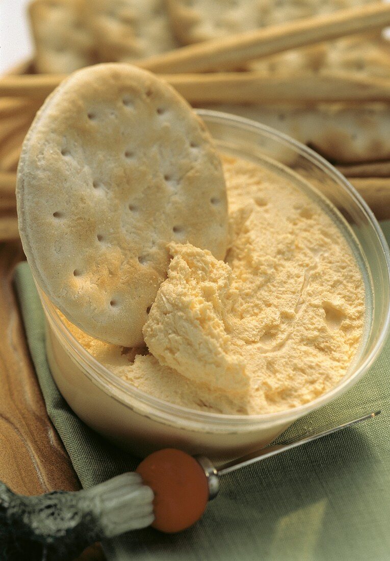 Cheddar-Cheese-Dip im Plastikbecher mit Cracker