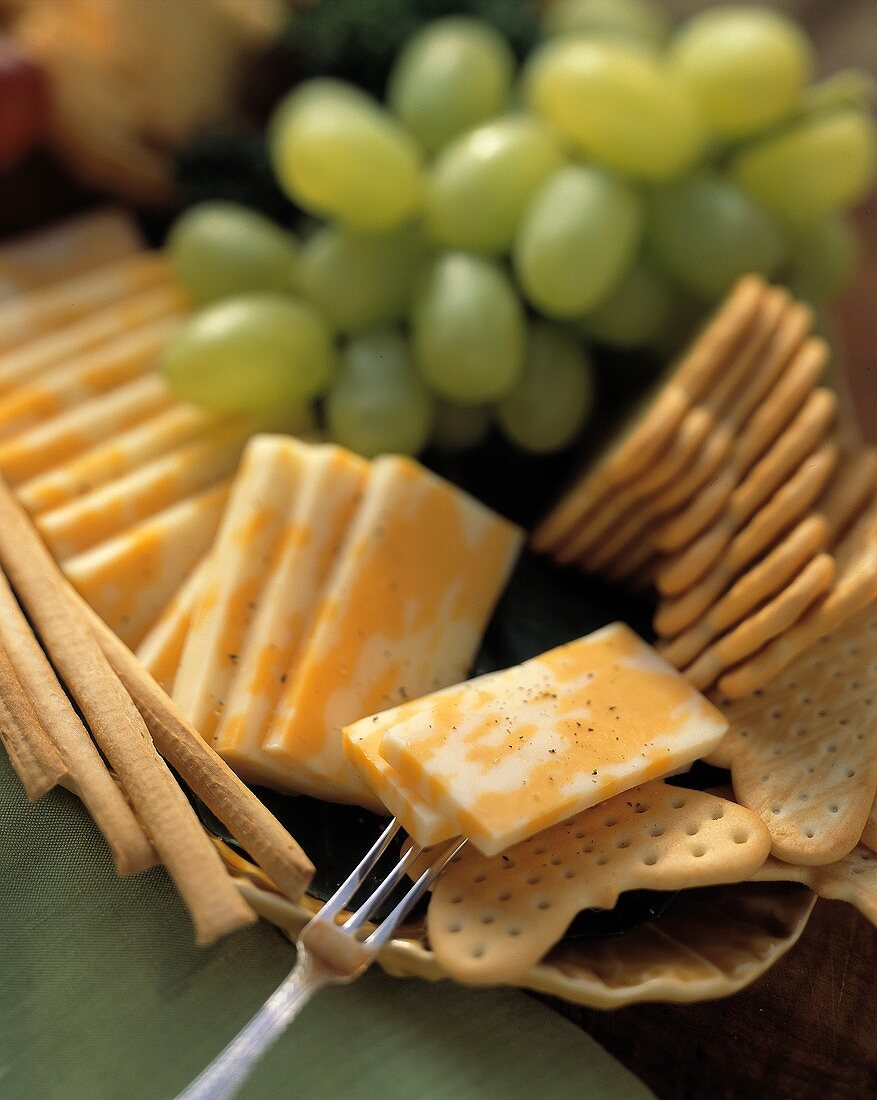 Käsescheiben mit Crackern, Grissini und Trauben