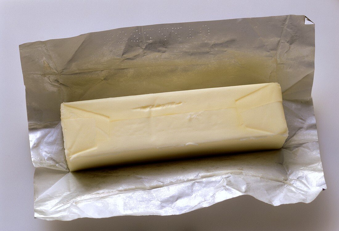 Ein Stück Butter auf Verpackungspapier