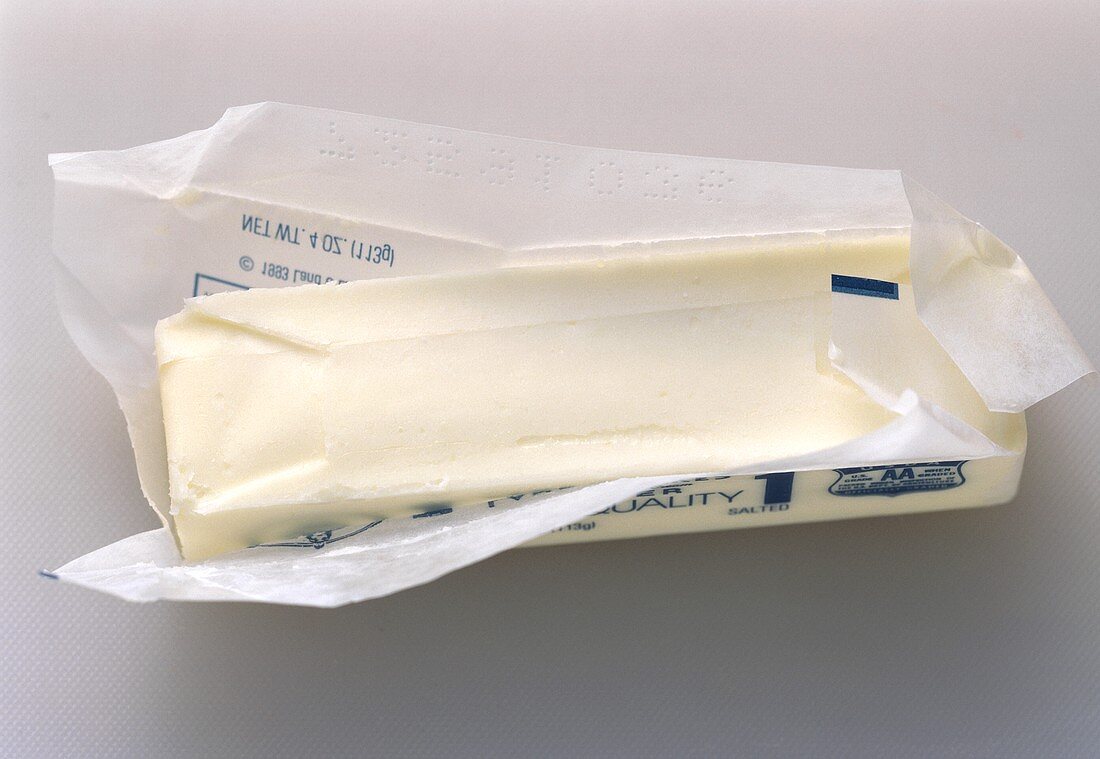 Ein Stück Butter in geöffneter Verpackung