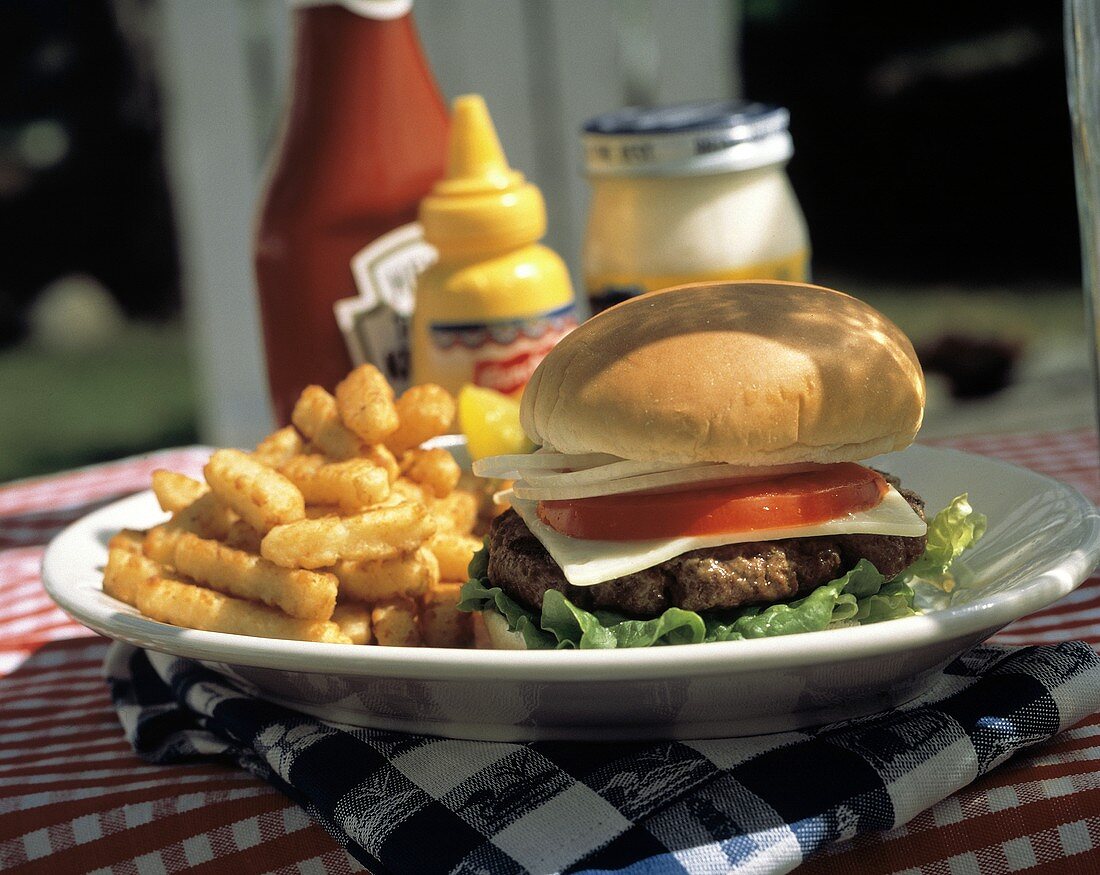 Ein Cheeseburger mit Pommes frites auf Teller am Tisch