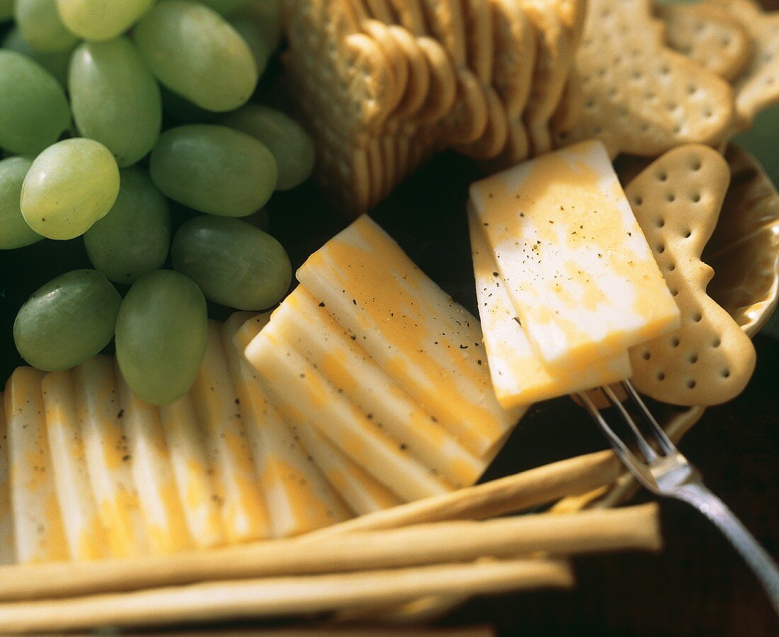 Marmorierte Käsescheiben mit Crackern & grünen Trauben