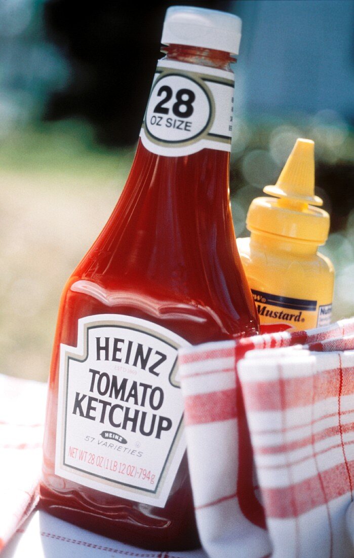 Eine Flasche Ketchup, Senf und Geschirrtücher im Freien
