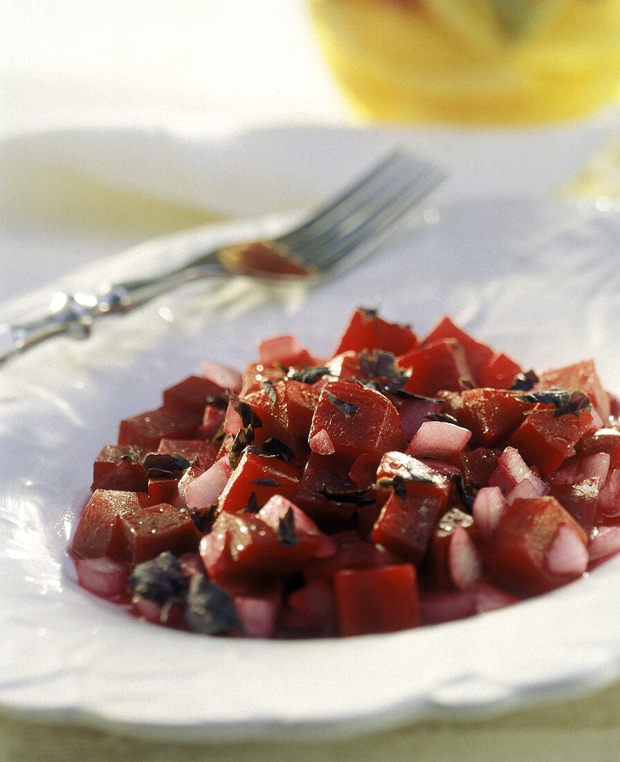 Rote-Bete-Salat mit Zwiebeln auf weißem Teller mit Gabel