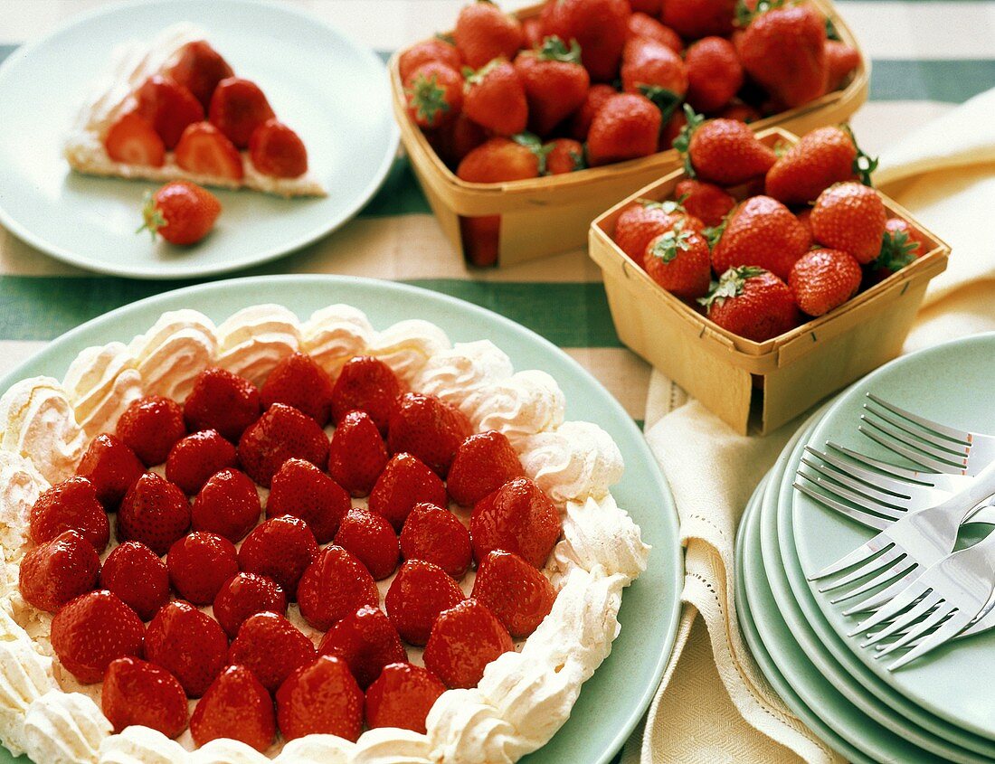 Eine Erdbeerbaisertorte & frische Erdbeeren in Spankörbchen