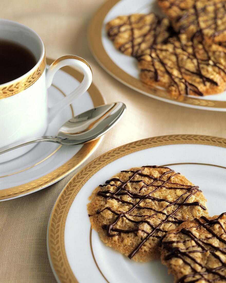 Pecannusskekse mit Schokoladenstreifen auf Tellern; Kaffee