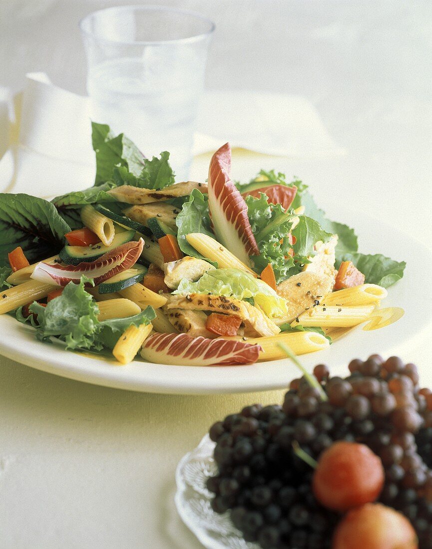 Blattsalat mit Hähnchenstreifen & Nudeln auf Teller