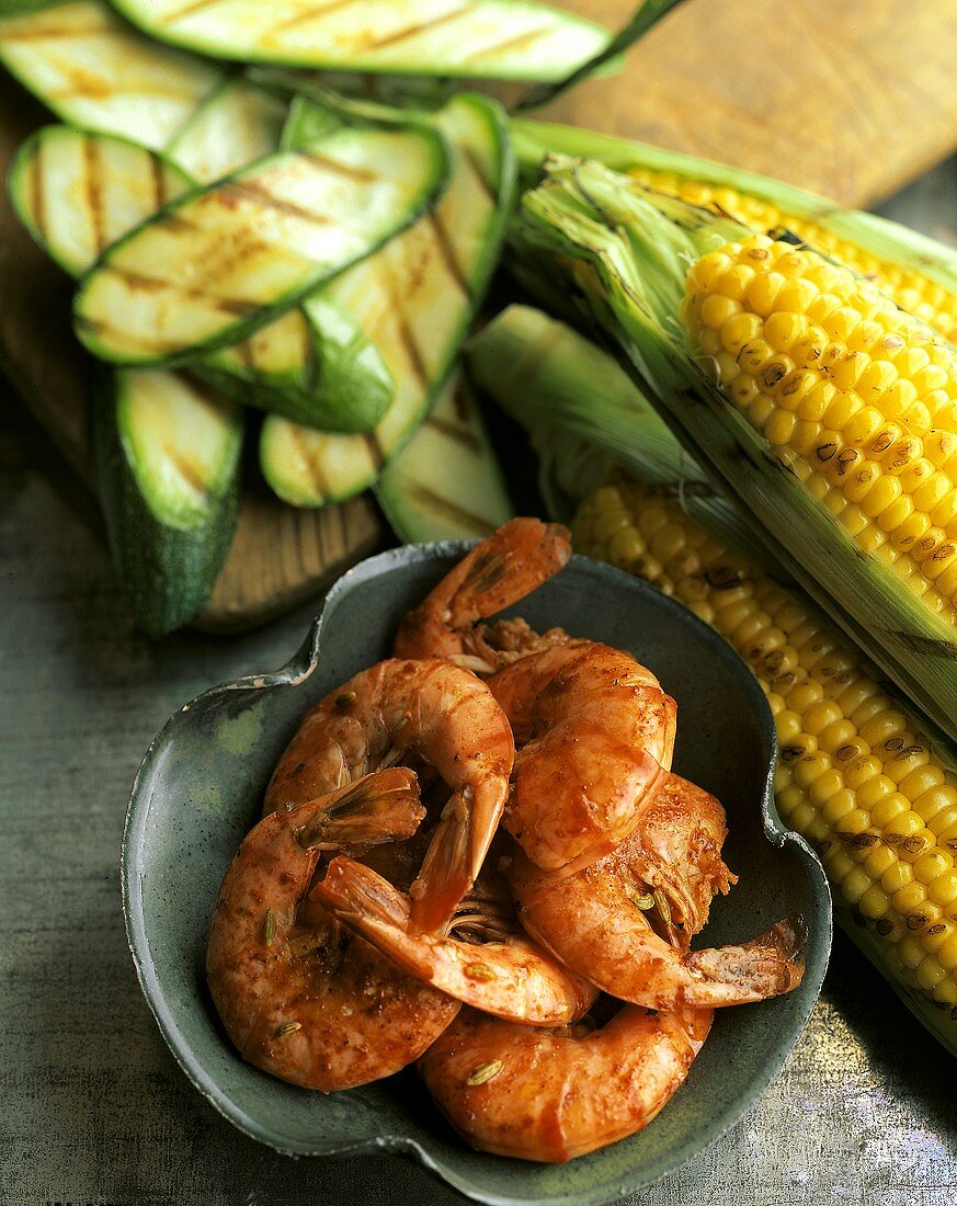 Würzige Garnelen im Schälchen; gegrillte Maiskolben, Zucchini