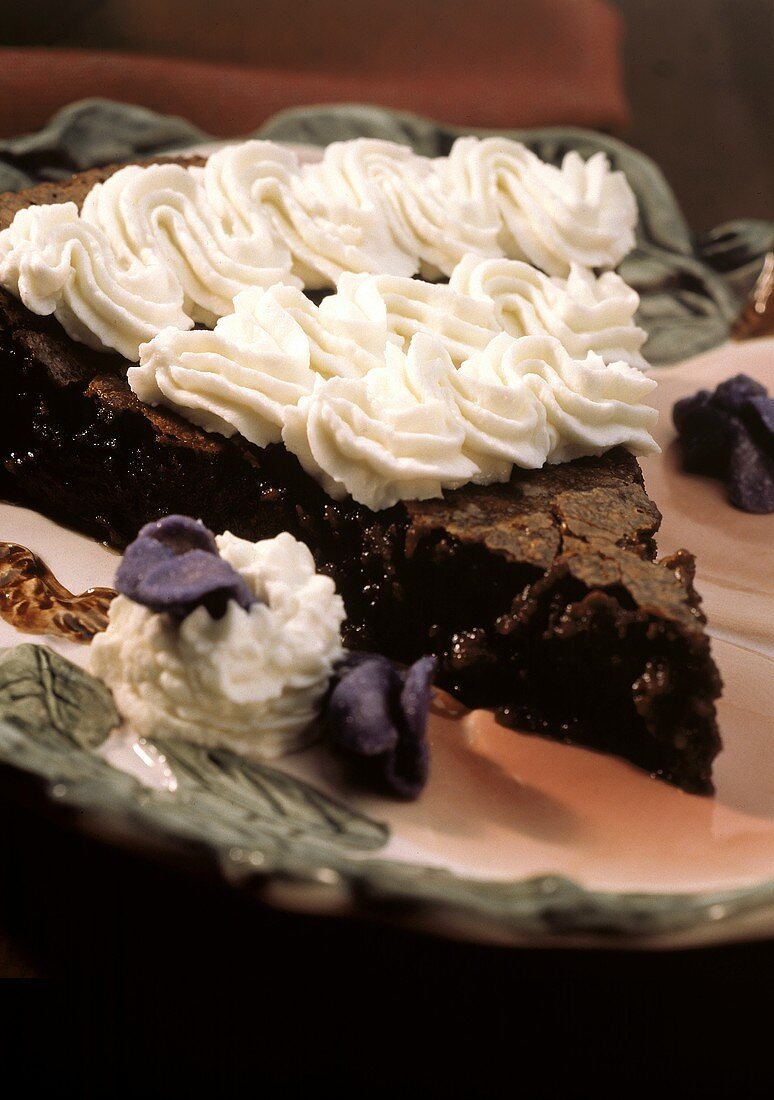 Ein Stück Schokoladenkuchen ohne Mehl, mit Sahne dekoriert