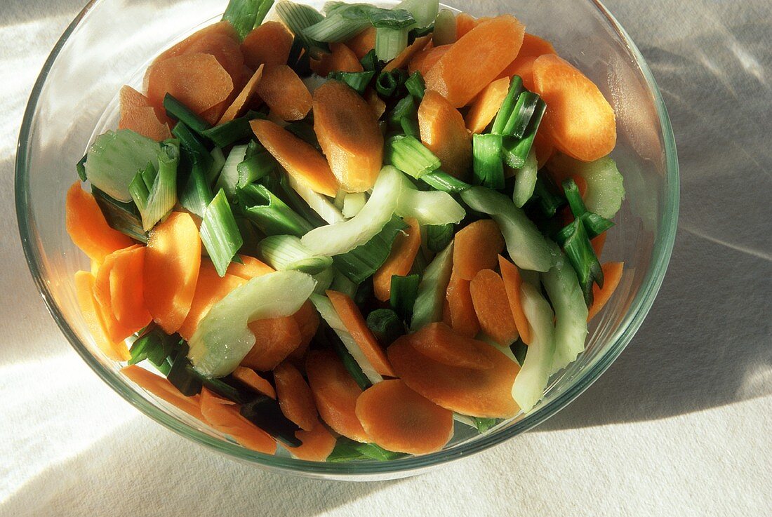 Chopped Celery Carrots and Scallions in a Glass Bowl