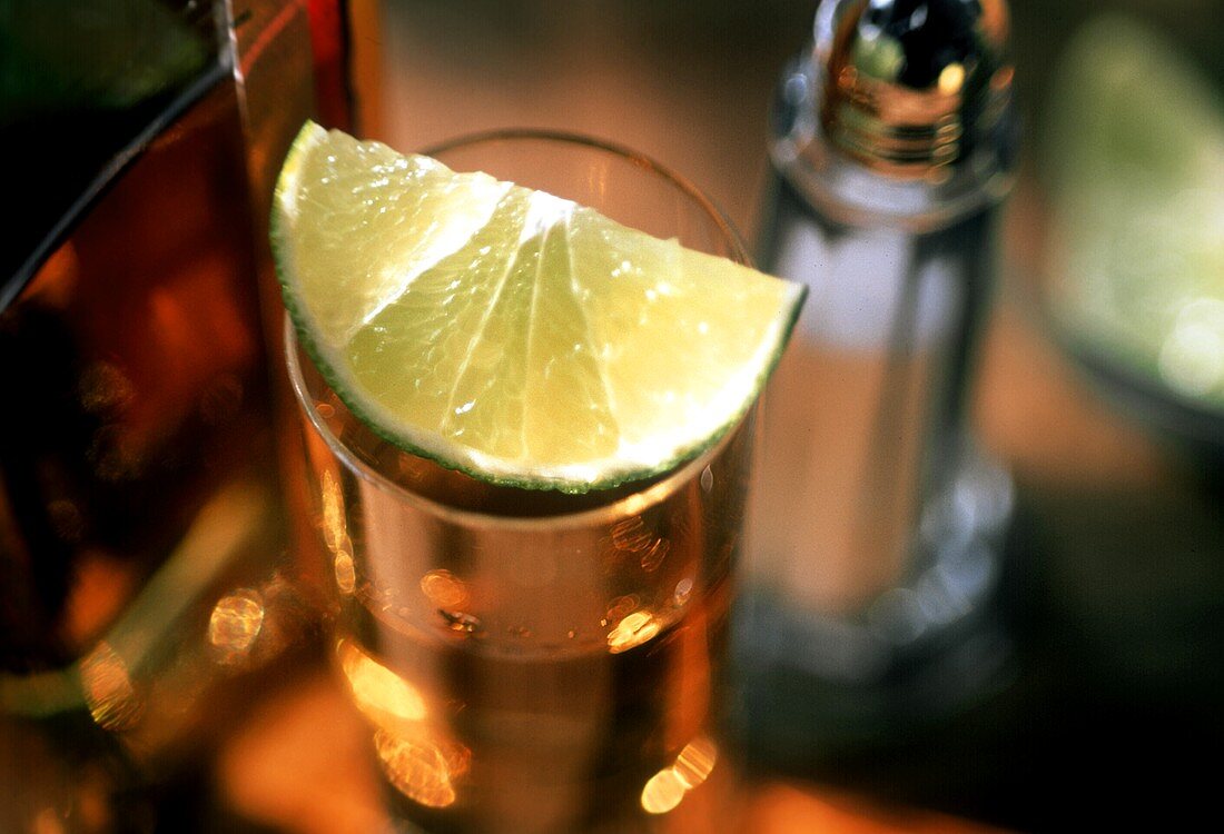 Ein Limettenschnitz auf einem Glas Tequila