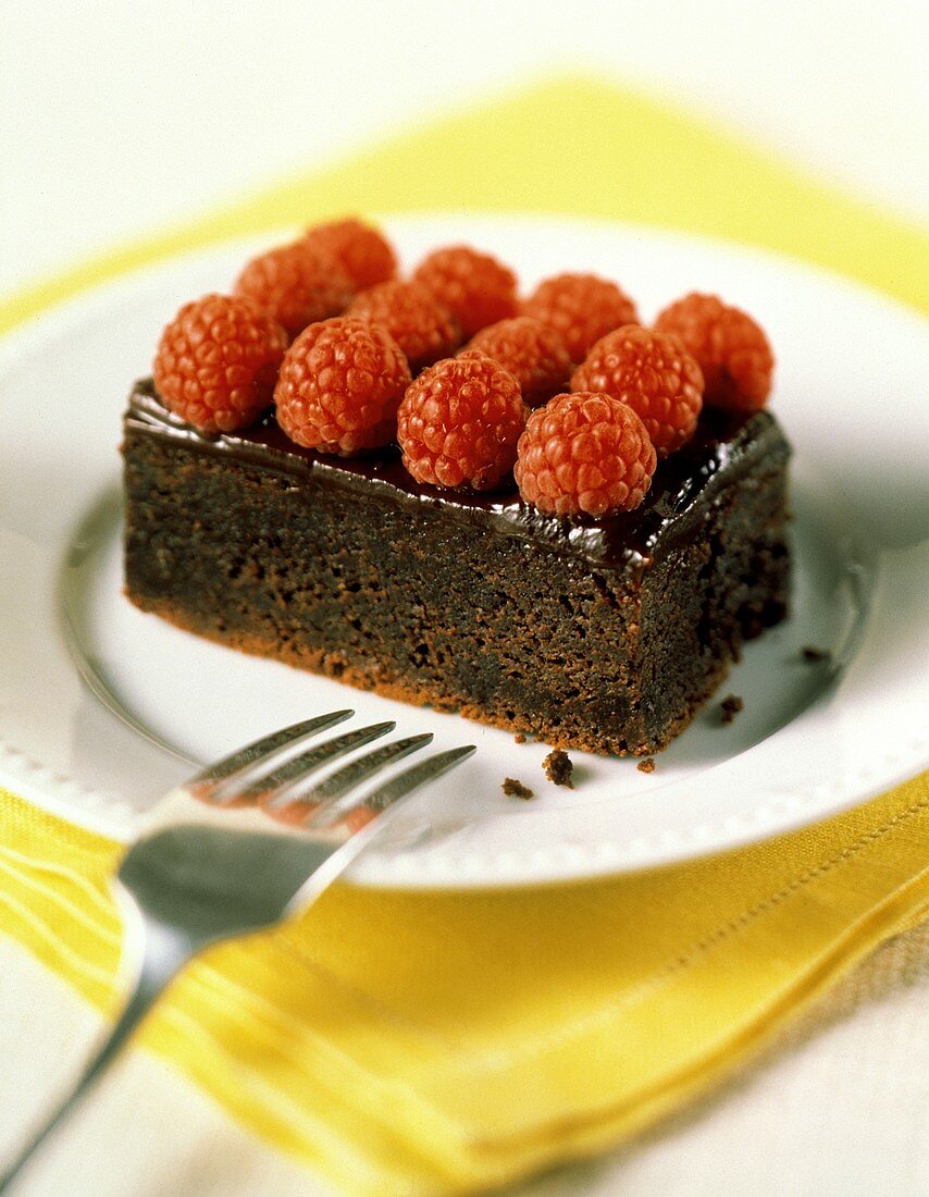 Ein Stück Schokoladenkuchen mit frischen Himbeeren