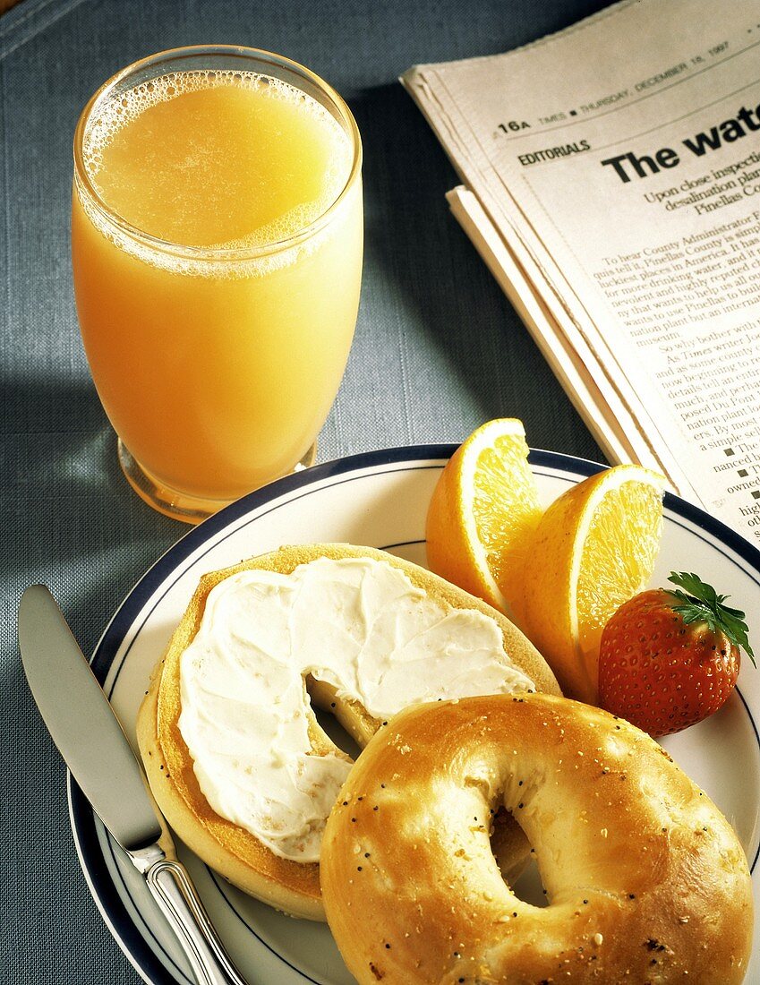 Bagel with Cream Cheese and Orange Juice; Newspaper