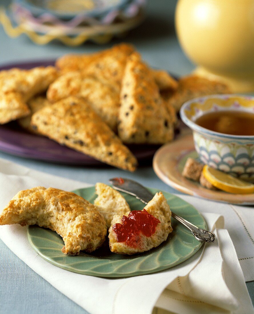 Scones, eines mit Marmelade belegt, zum Tee