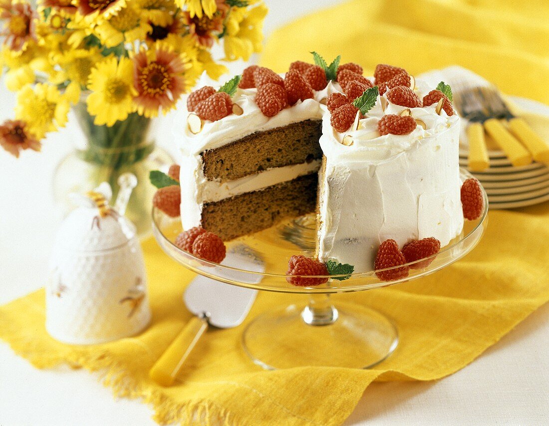 Torte mit weisser Creme und Himbeeren auf Kuchenplatte