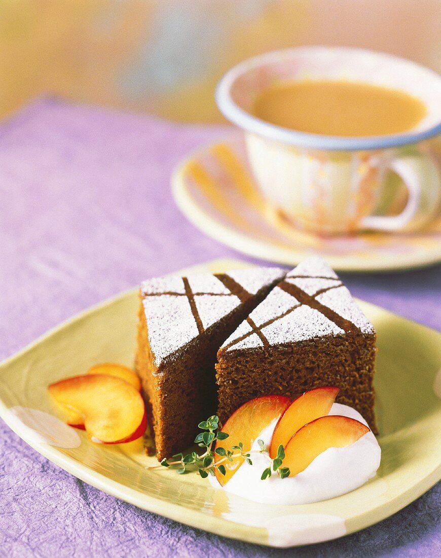 Schokoladenkuchen mit Puderzucker, Sahne, Nektarinen; Kaffee