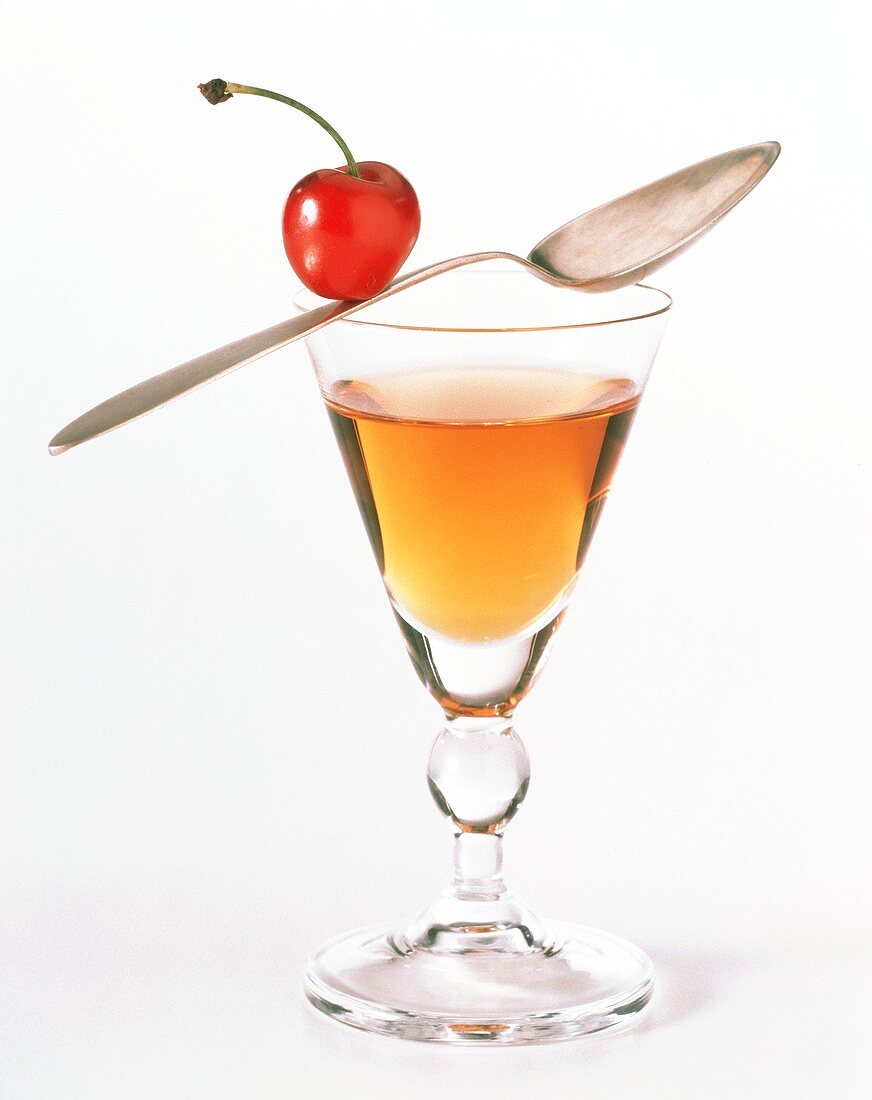 A Glass of Liqueur with a Spoon and Cherry