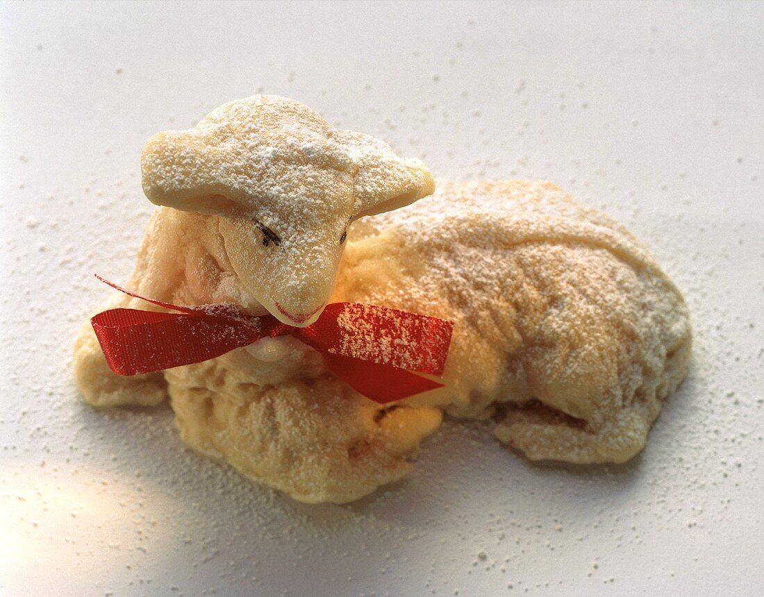Marzipan-Osterlamm mit roter Schleife und Puderzucker