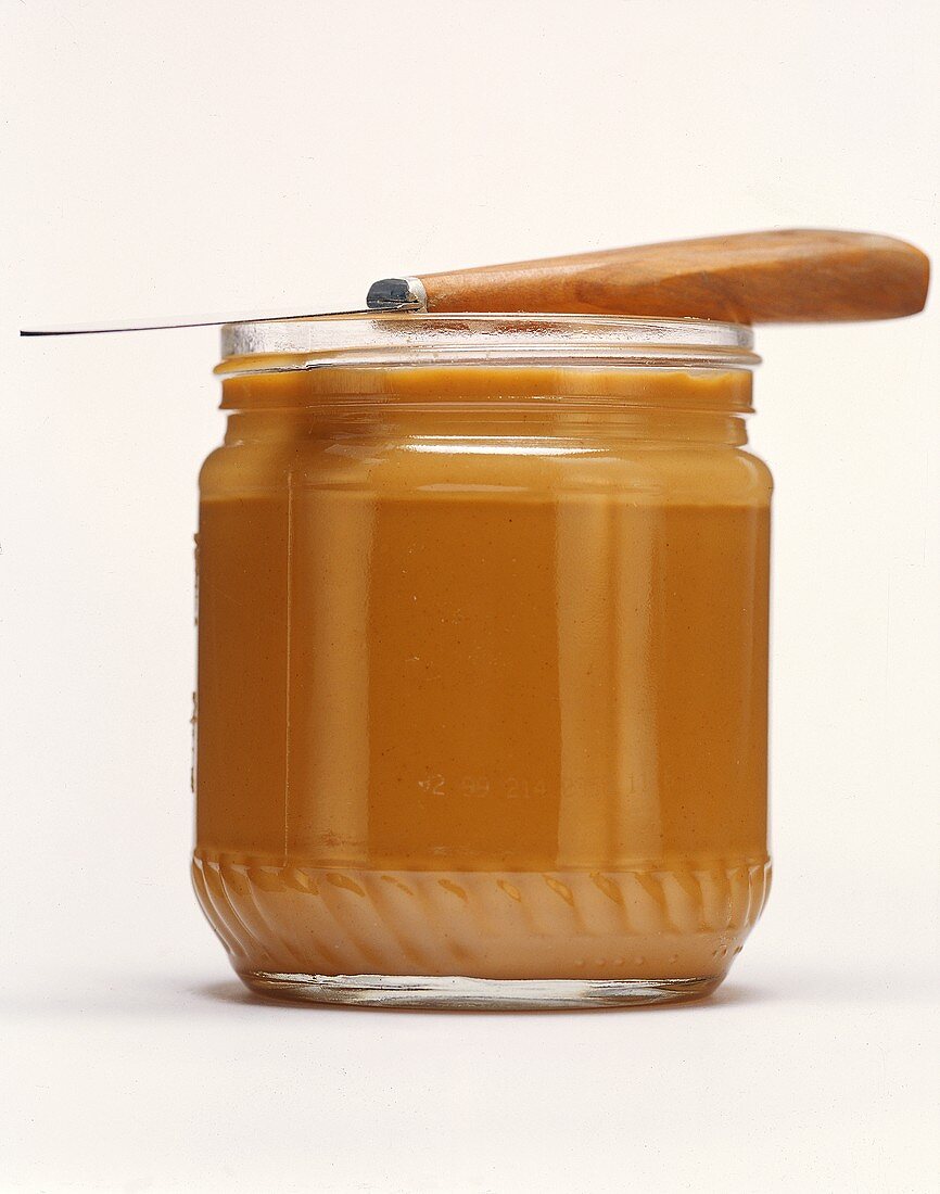 Opened Jar of Peanut Butter with Knife