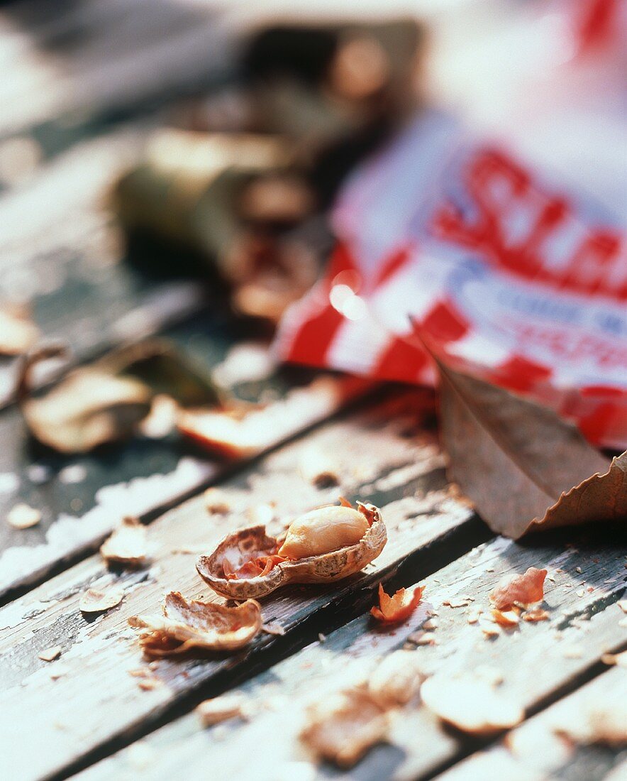 Erdnuss in der Schale vor Verpackung; herbstliche Blätter