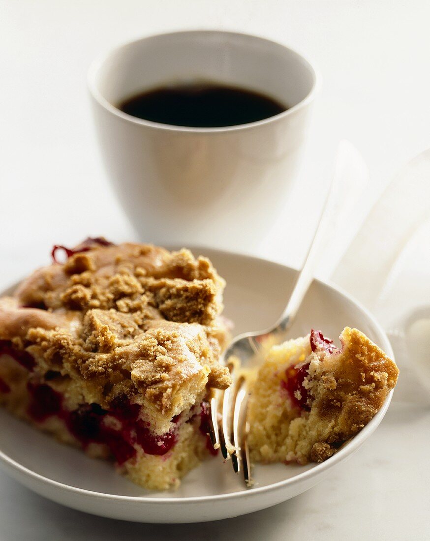 Piece of Cranberry Coffee Cake on a Plate with a Fork; Cup of Coffee