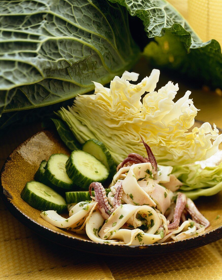 Tintenfischsalat mit Gurkenscheiben und Weißkohl