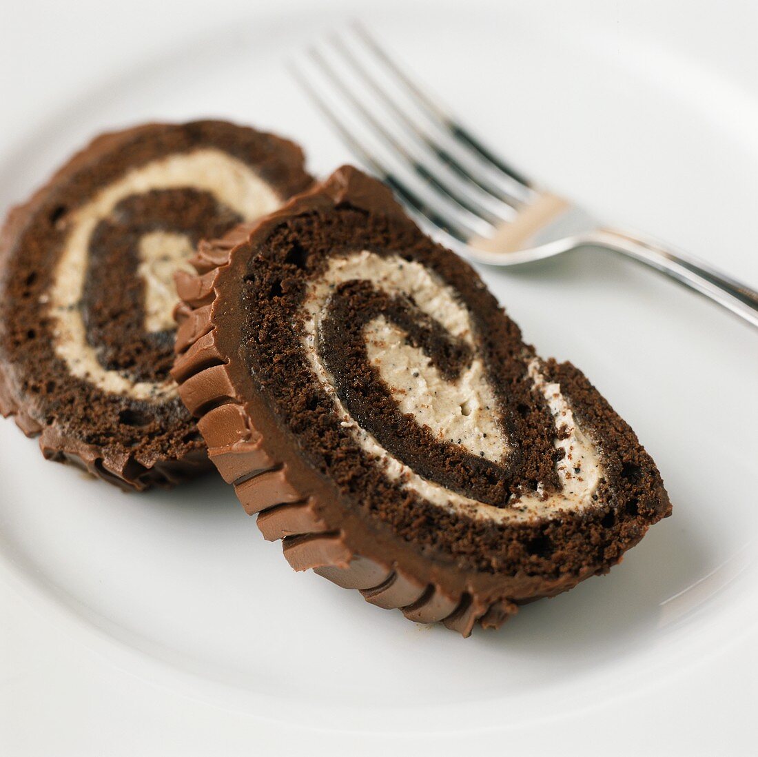 Two slices of chocolate Swiss roll with vanilla cream
