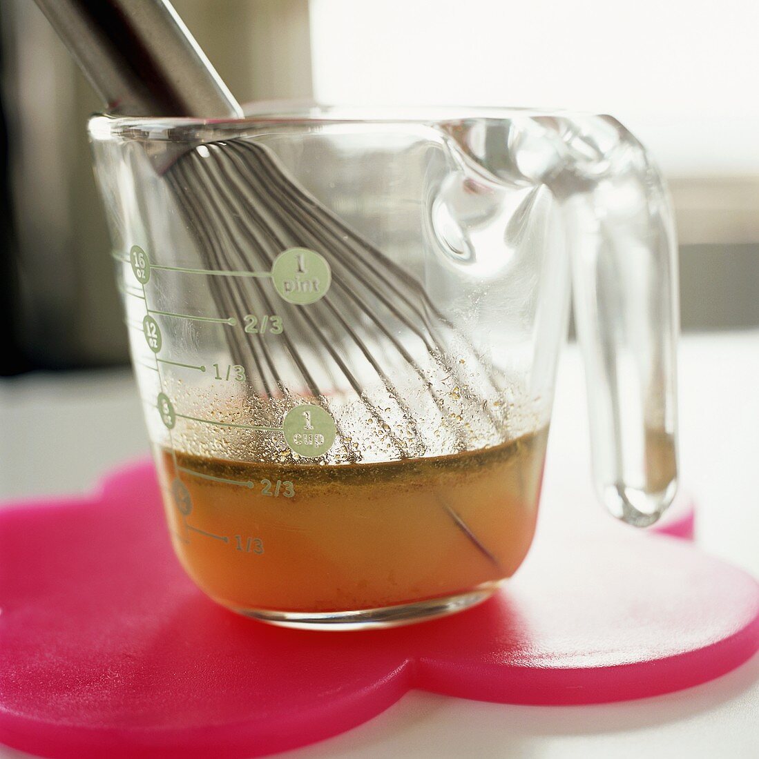 Stock in a measuring jug with a whisk