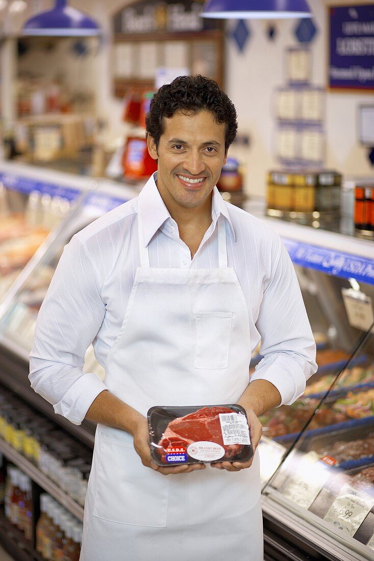 Metzger präsentiert verpacktes Steak im Supermarkt