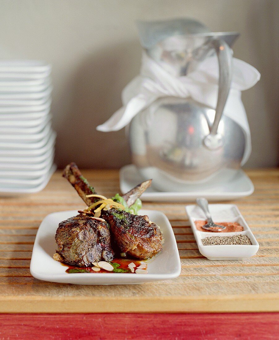 Fried lamb chops with flaked almonds, spices, water jug